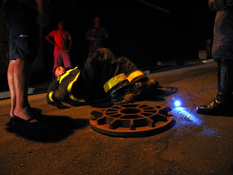 A plumber in uniform responding to a plumbing emergency at night.