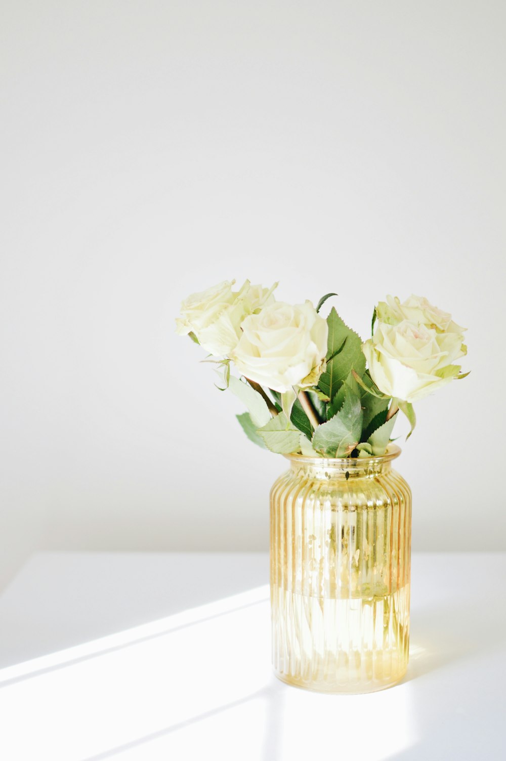 white rose centerpiece on white wooden table