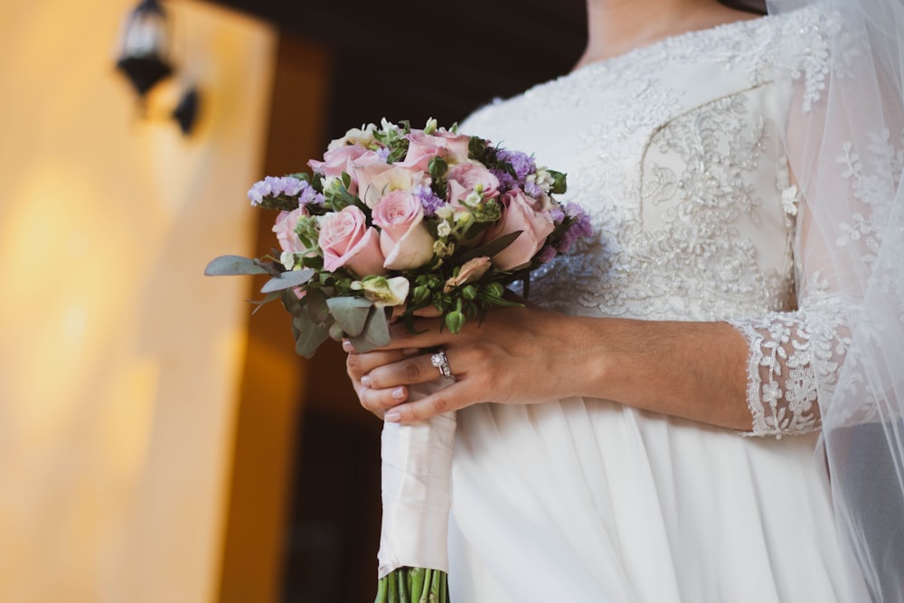 bride holding pink bouquet of rose