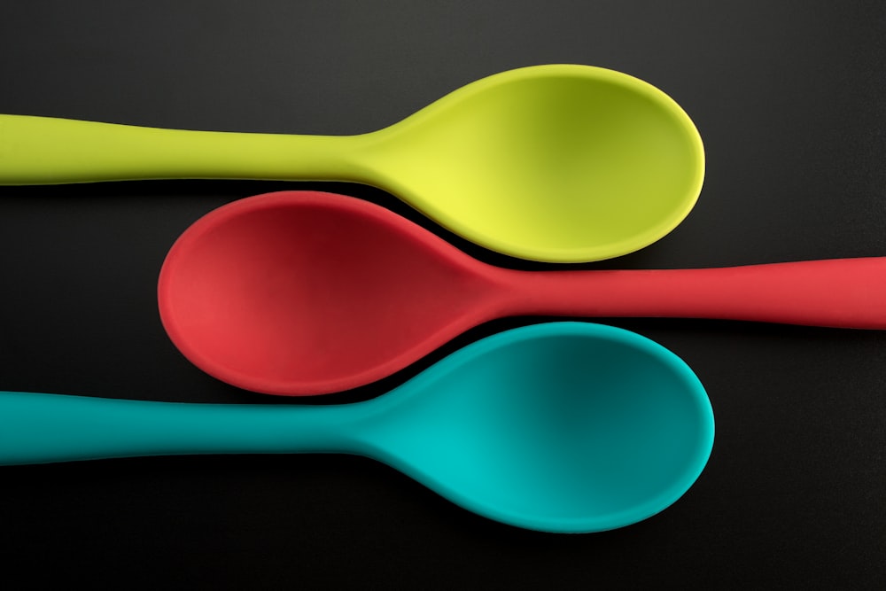three green, red, and blue plastic spoons