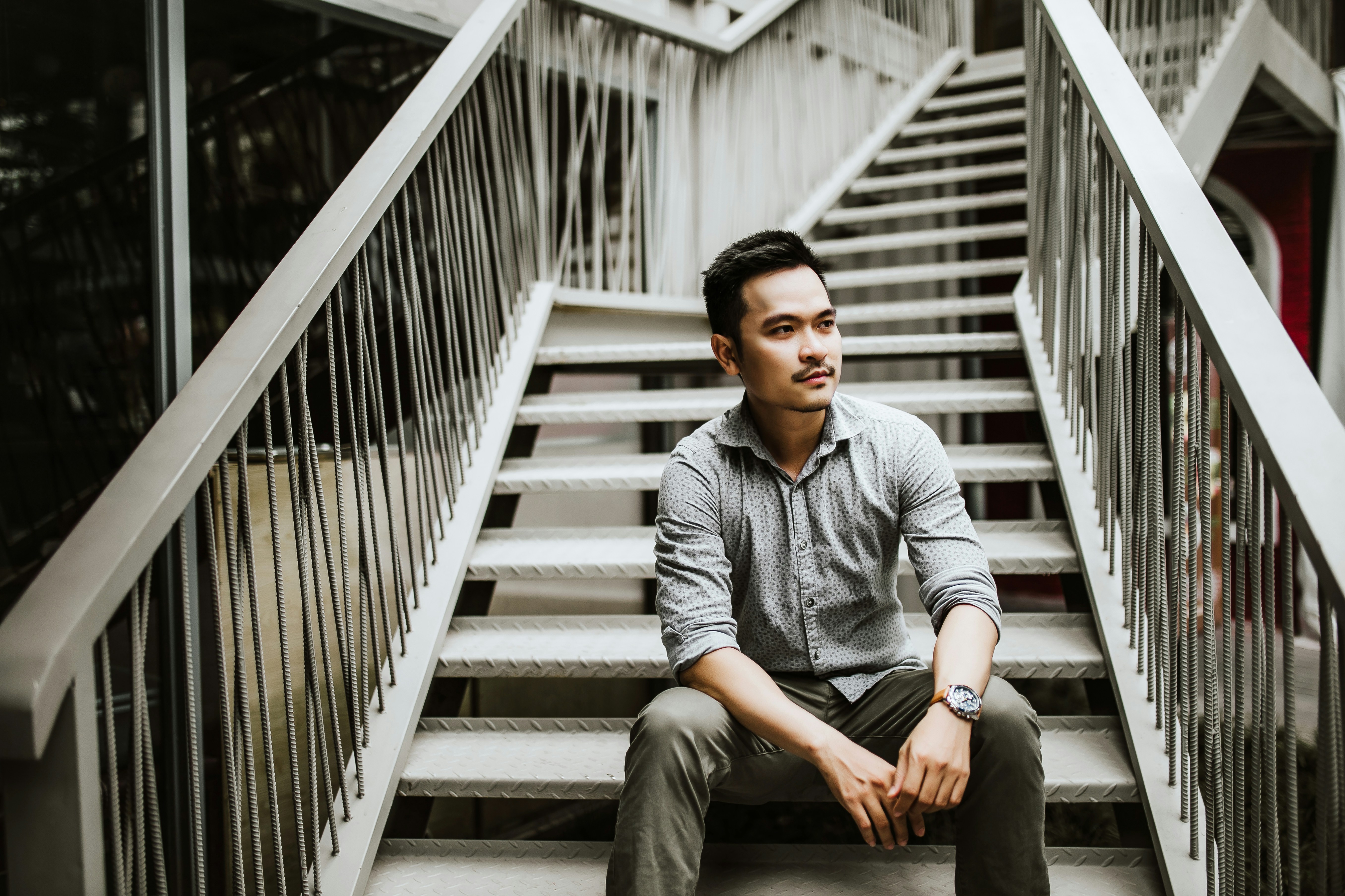 man sitting on stairs during daytime