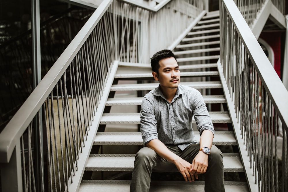 man sitting on stairs during daytime