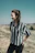 woman standing on green grass while hands in black pocket