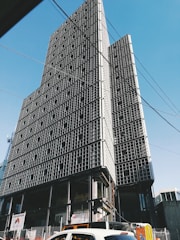 A sleek modern office building under construction with steel framework against a clear sky.