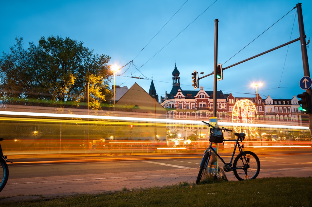 timelapse photo of bicycle parked near road and concrete building