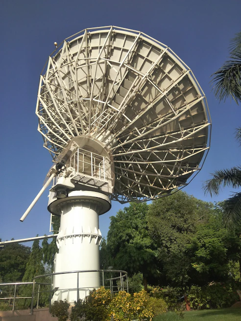 Close-up of a professional technician aligning a satellite dish precisely against a clear Riyadh sky