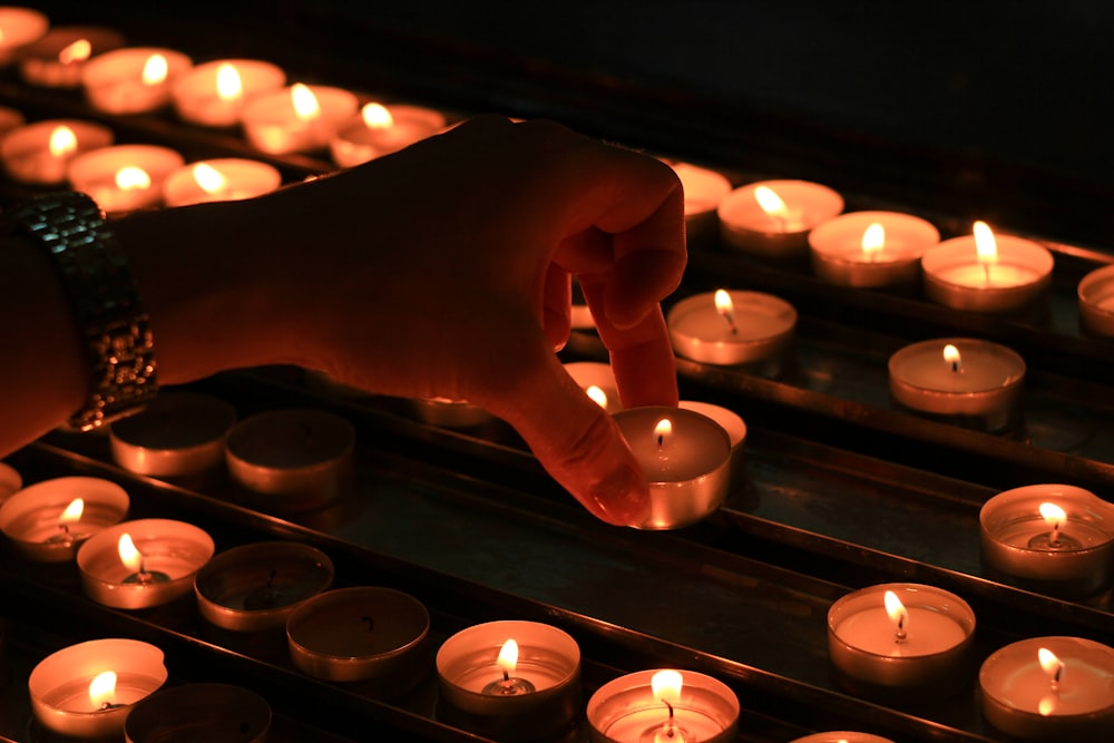 person holding white scented candle