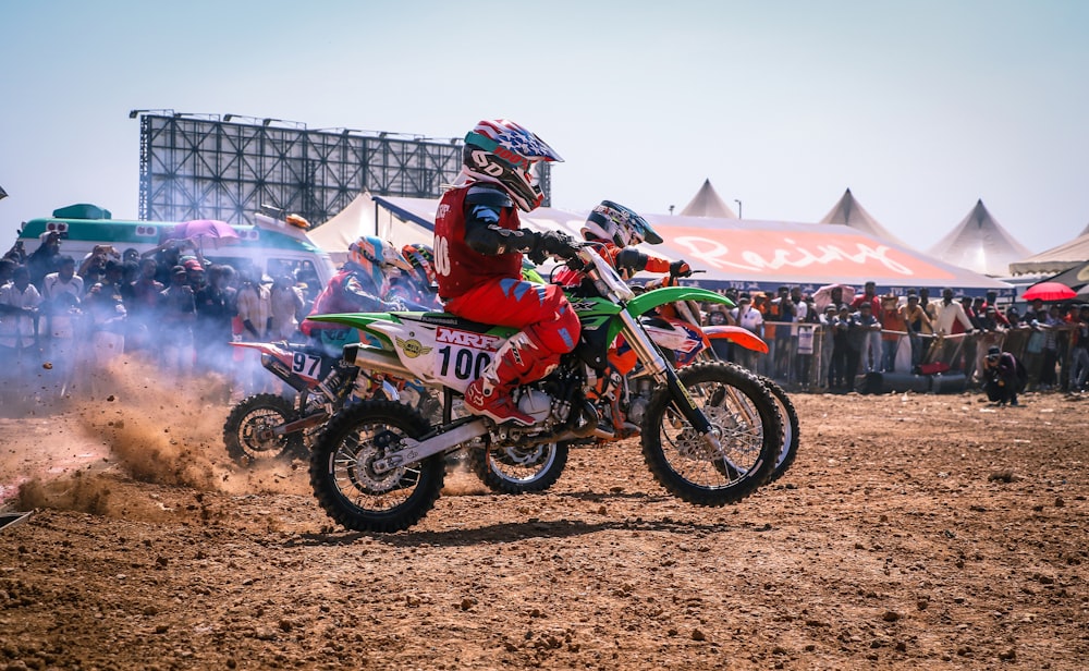 Motocross-Dirtbike-Rennen mit Leuten, die neben dem Foto im Fokus zuschauen