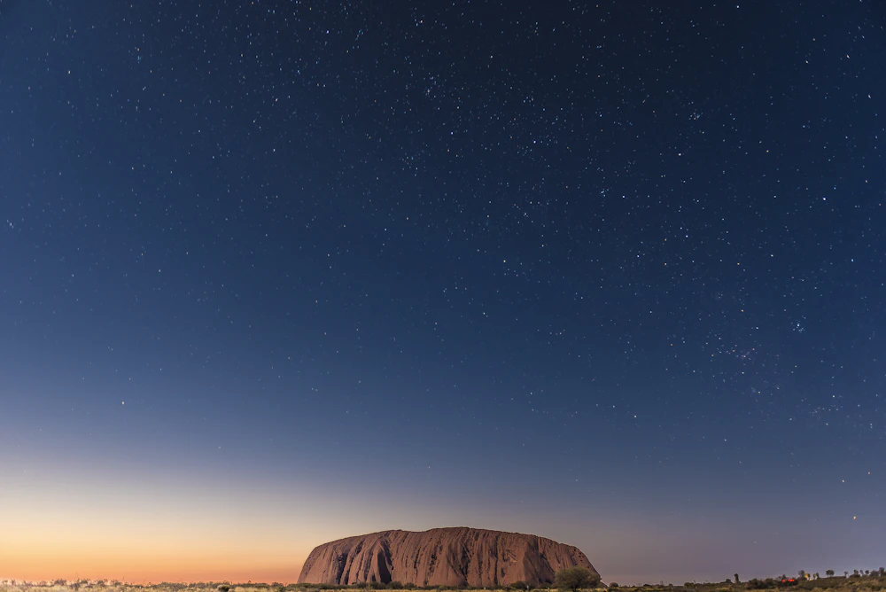 Uluru bajo el cielo estrellado al anochecer