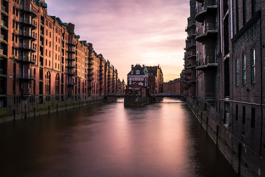 lake view surrounded by concrete building during daytime in Speicherstadt Germany