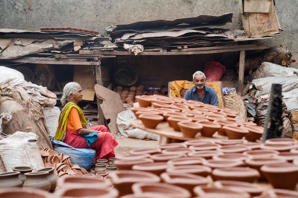 two person sitting near clay pots