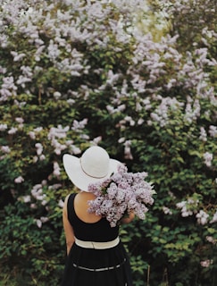 person carrying purple flowers