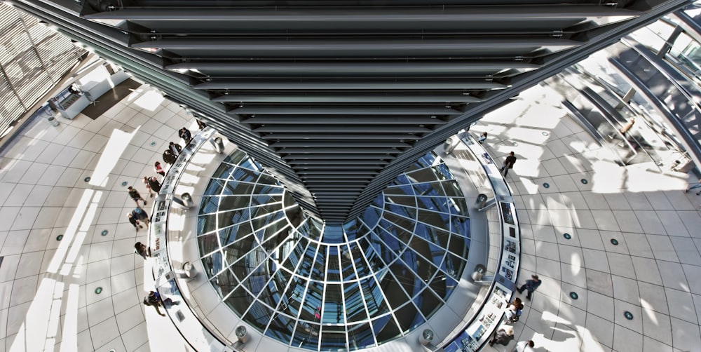 high-angle photography of people standing inside white and black concrete building during daytime