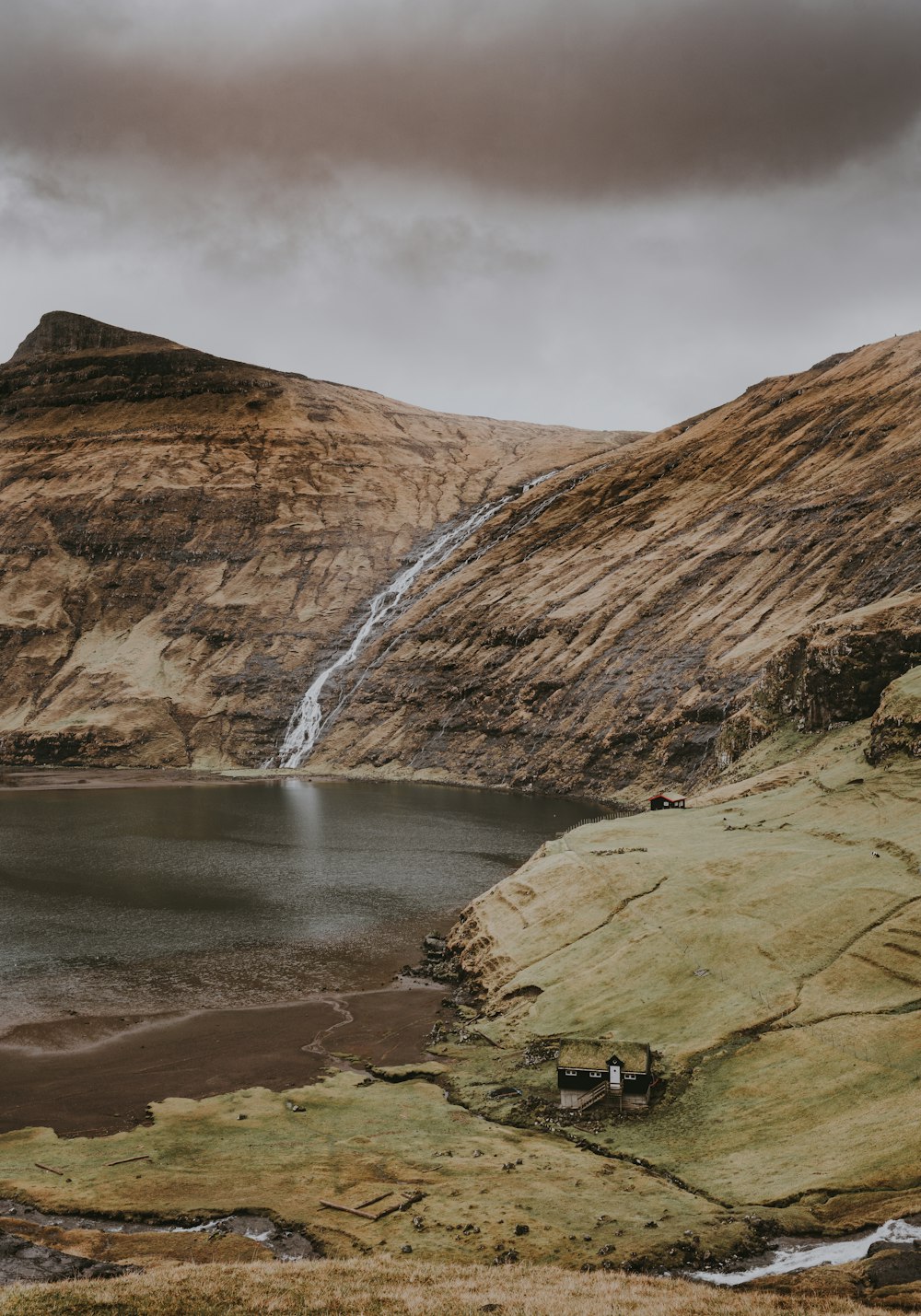 Montaña de roca marrón con cascadas