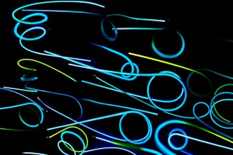 Abstract blue and emerald glowing lines forming a digital network pattern on a black background.