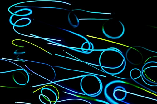 Close-up of neon blue and violet glowing micro-interactions on a black background.