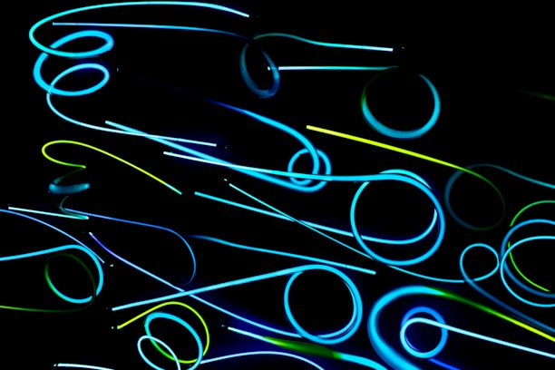 A glowing teal and neon green abstract 3D fiber-optic DNA helix twisting against a pitch black OLED background.