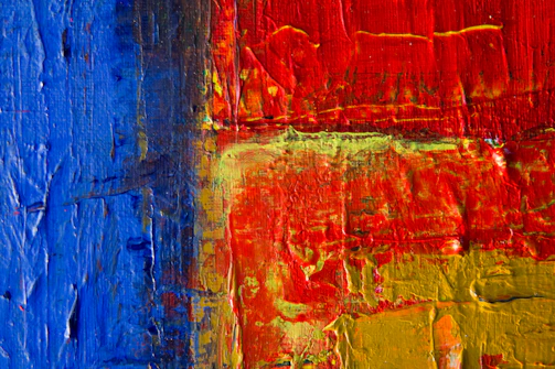 Close-up of a vibrant, textured acrylic painting with bold strokes.