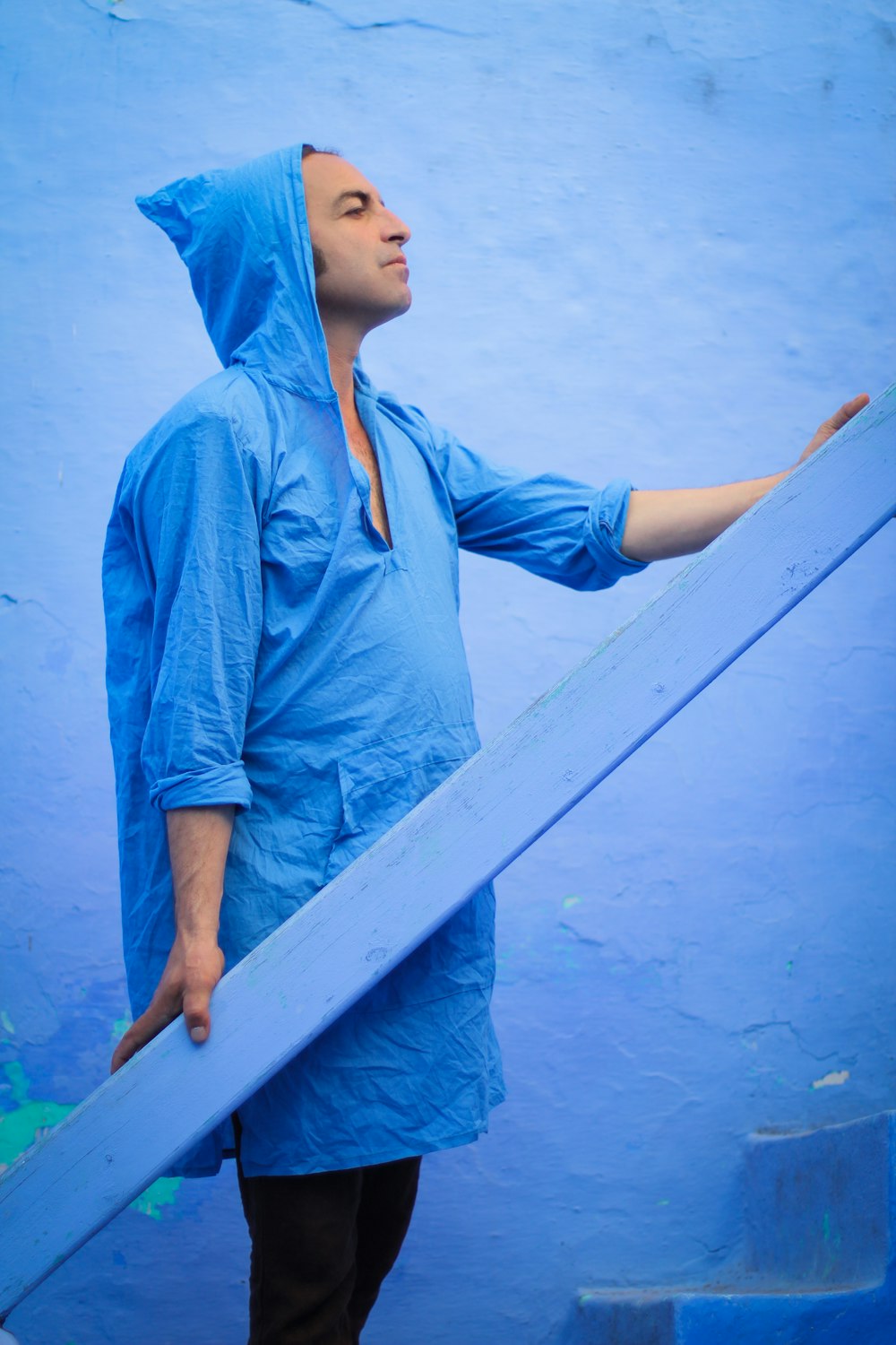 man holding blue plank
