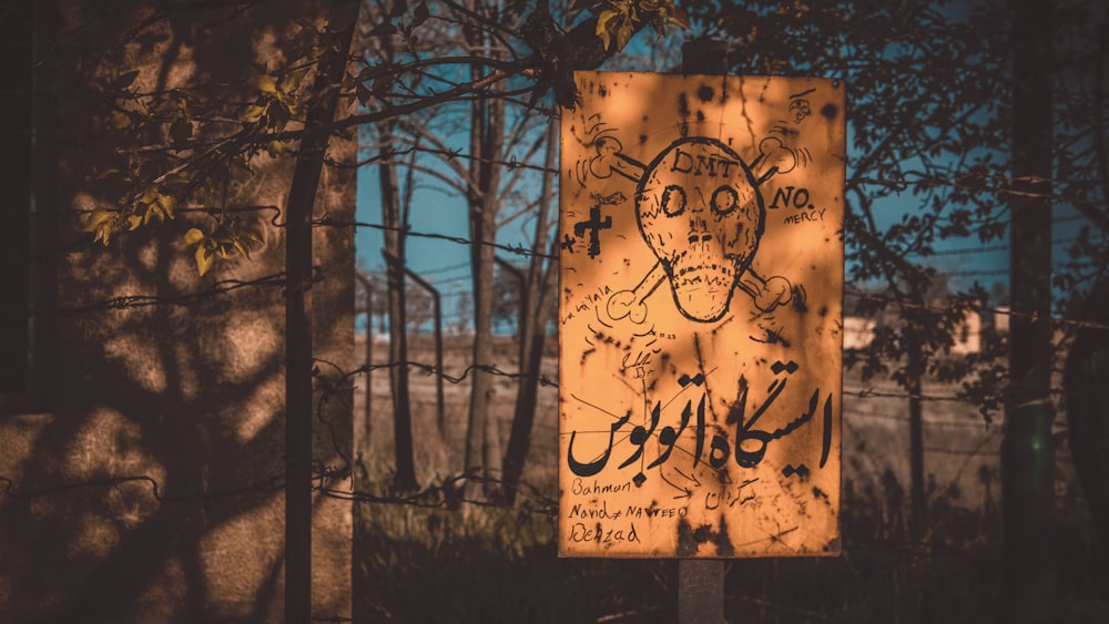 beige and brown skull with x sign on fence