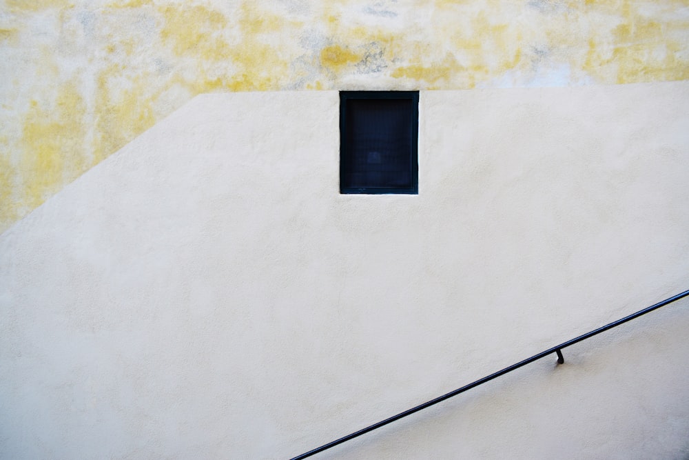 Un bâtiment jaune et blanc avec une fenêtre