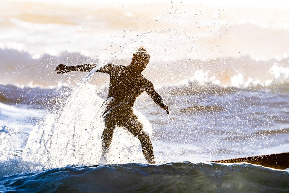 Silhouettenfotografie eines Mannes, der auf einem Gewässer surft