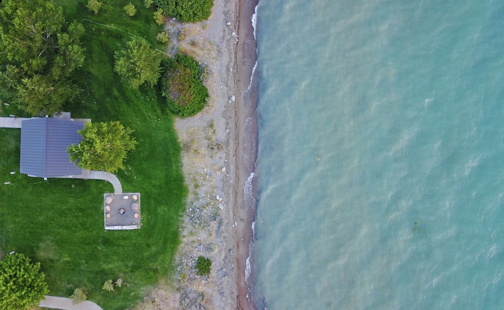 an aerial view of a house next to the ocean