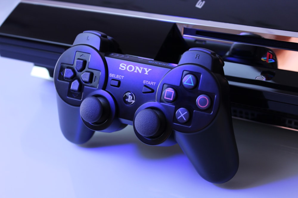 Controlador Sony PS2 negro sobre superficie blanca
