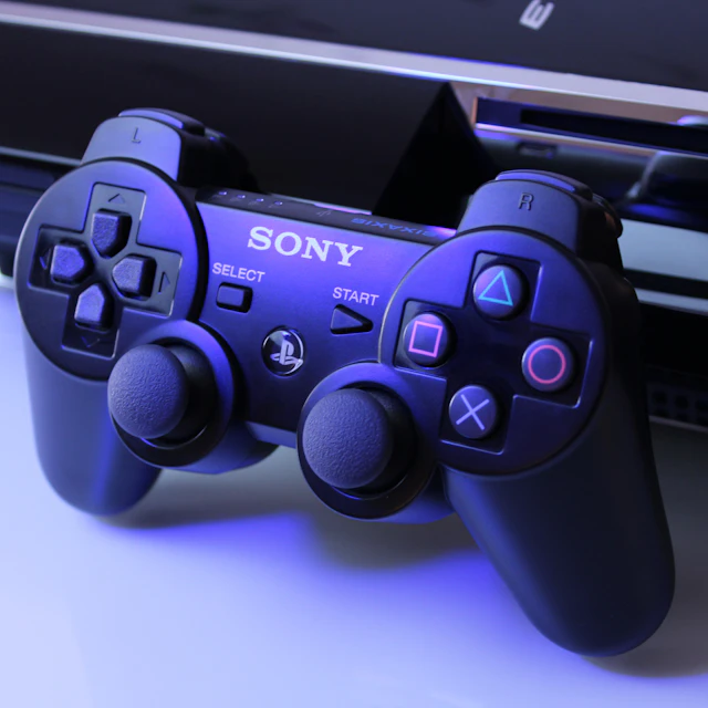 Black Sony PlayStation 2 controller on a white surface
