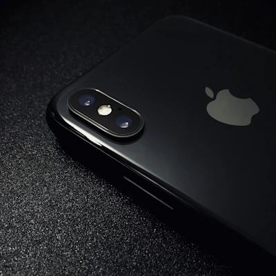 A close-up shot of a shiny Apple iPhone showcasing its elegant glass back and iconic logo.