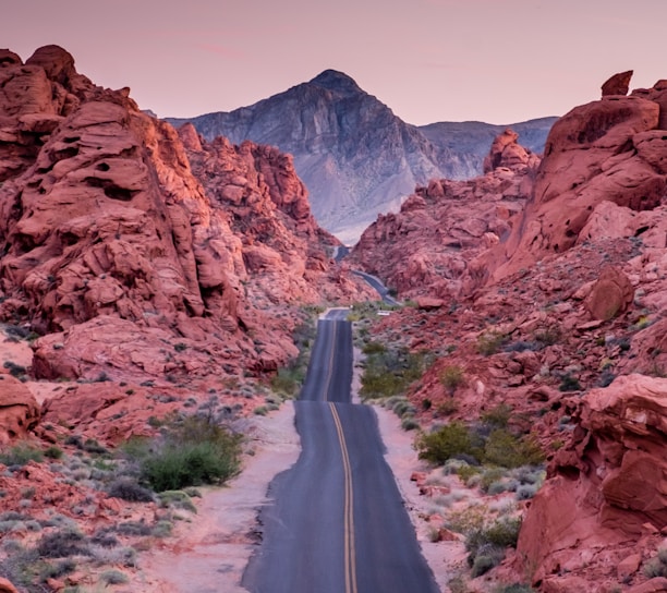 photo of empty road between rock formations