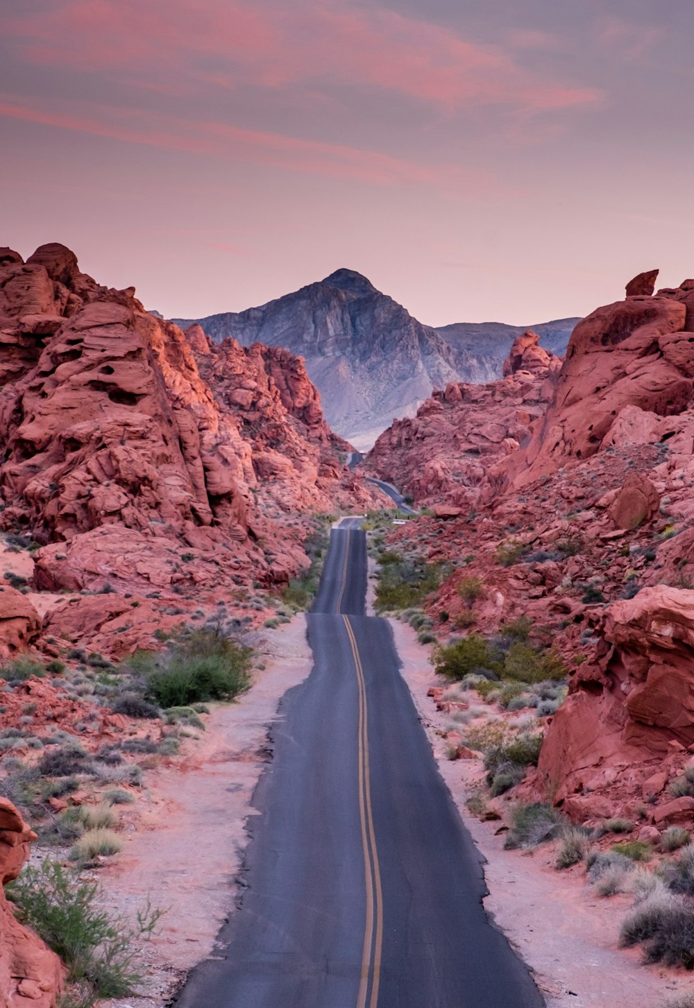 photo of empty road between rock formations