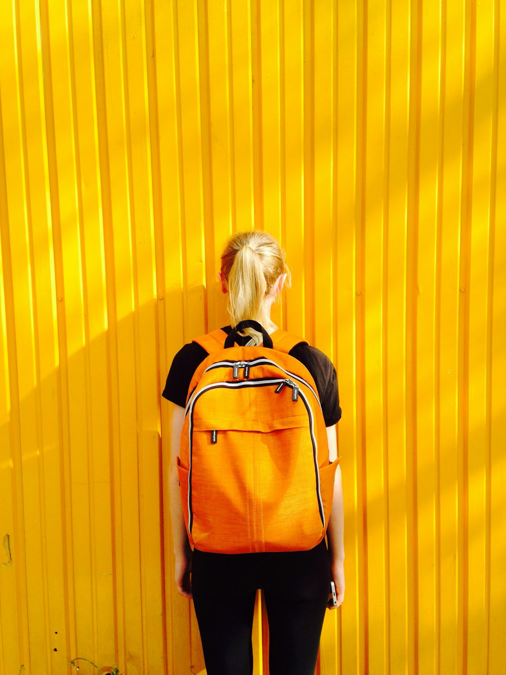 Foto de mujer frente a pared amarilla