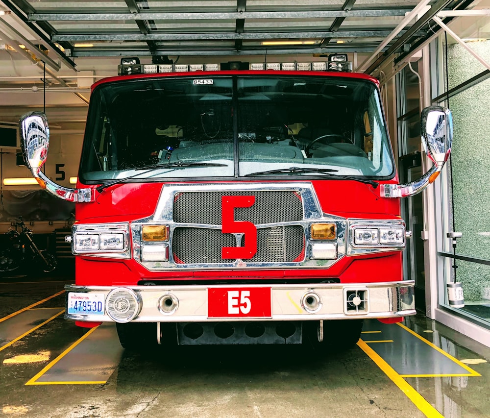 red and gray fire truck parked inside building