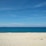 A serene beach with clear blue waters and soft white sand.