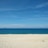 A serene beach with clear blue waters and soft white sand.
