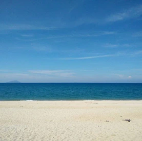 A serene beach with crystal clear waters and soft sand.