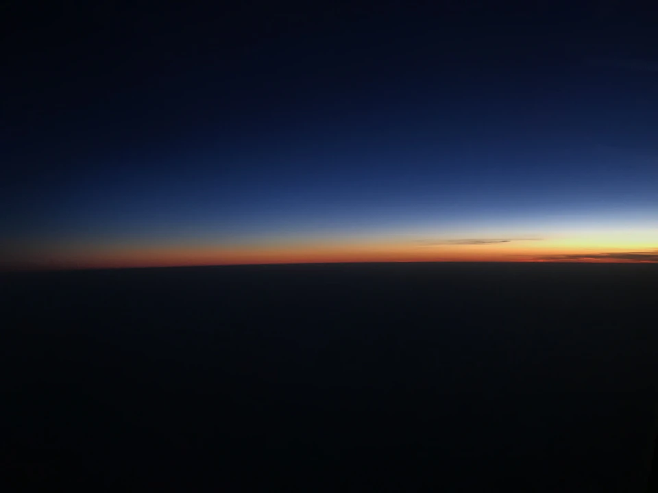 Atardecer visto desde la ventanilla de un avión sobre el mar