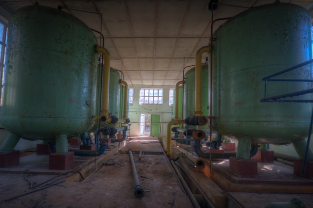 A team of engineers inspecting a modular leaching plant under bright daylight.