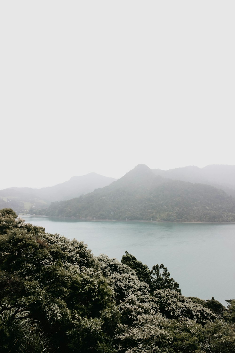 body of water and mountain surrounded with fog