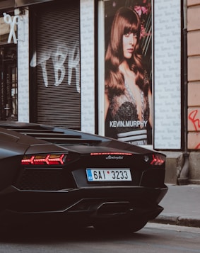 black Lamborghini beside Kevin Murphy poster