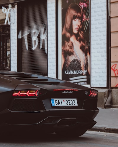 black Lamborghini beside Kevin Murphy poster