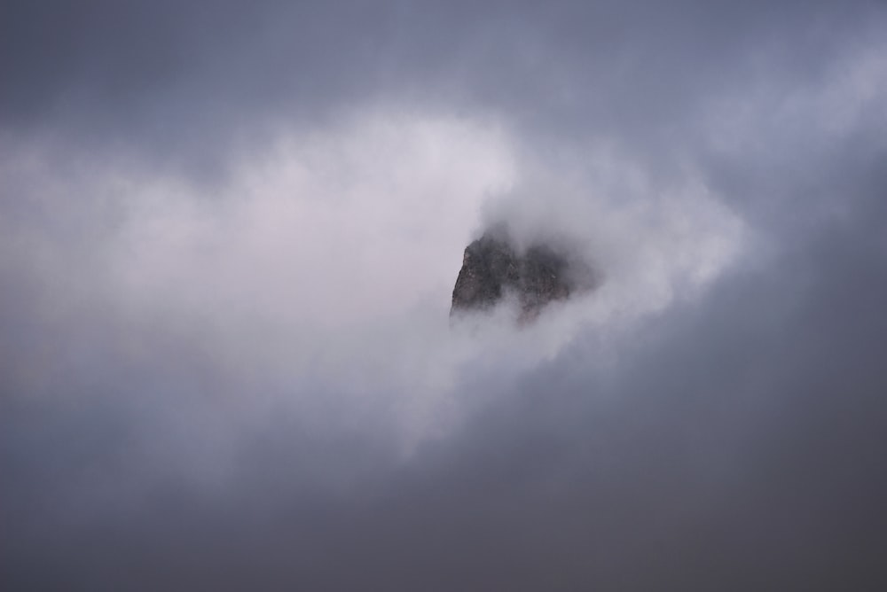 a large rock sticking out of the clouds