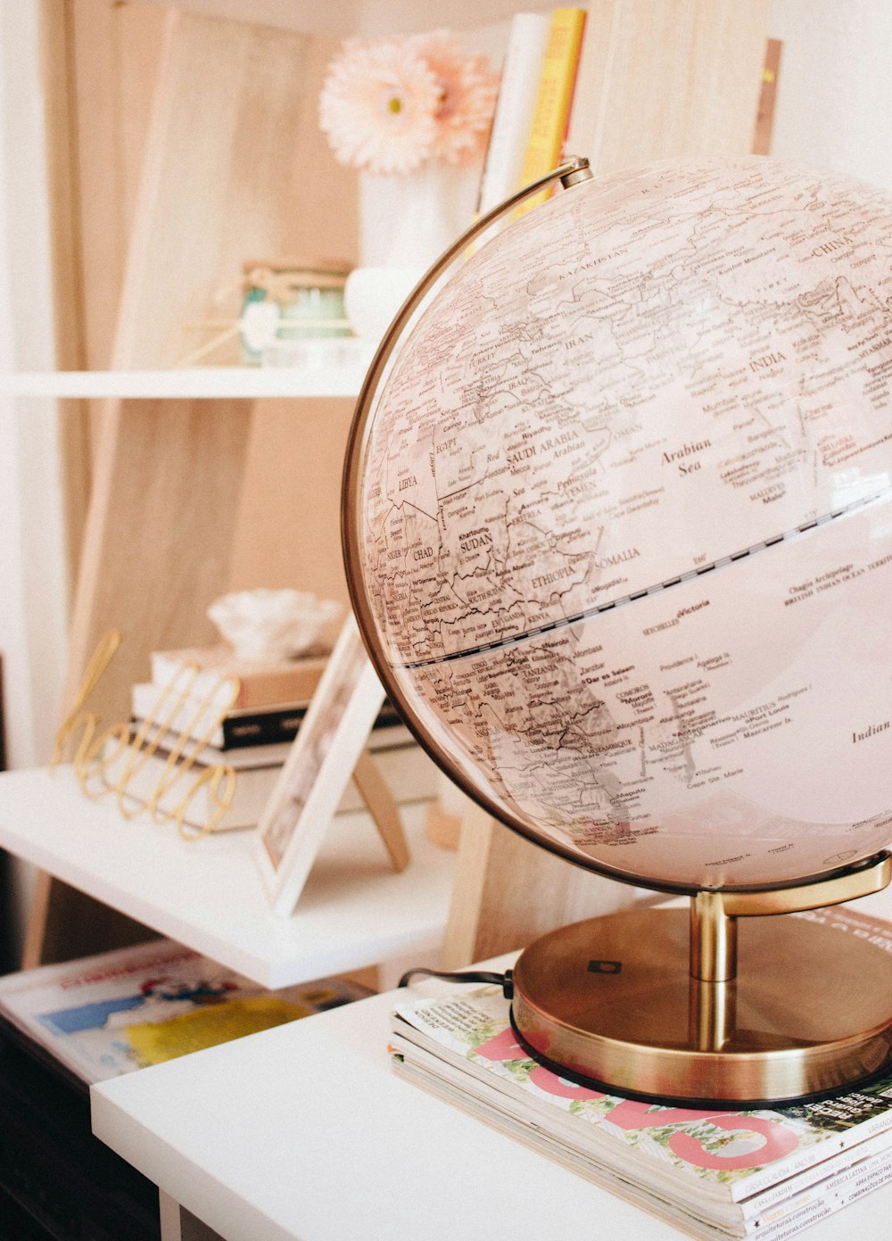 white and black desk globe on the top of magazines
