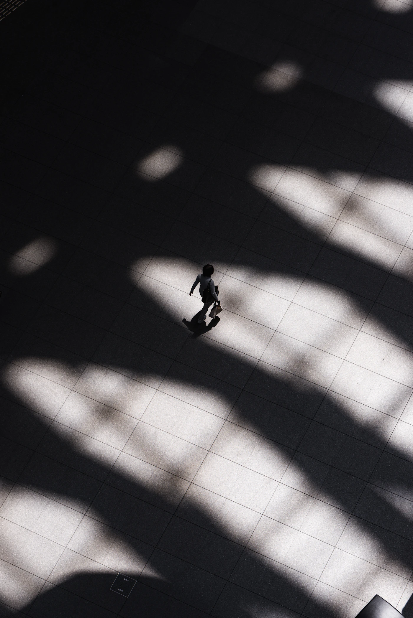 Person walking across a bright geometric floor with strong spacing