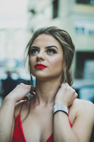 A sophisticated evening look featuring a sleek black dress paired with bold red lipstick.