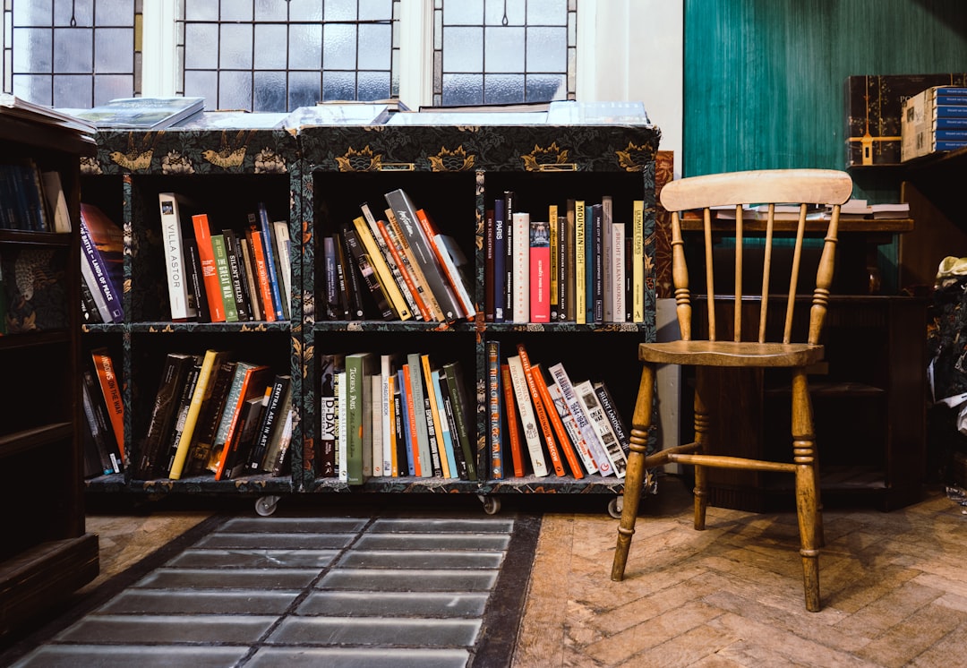 brown wooden windsor chair near black wooden bookshelf