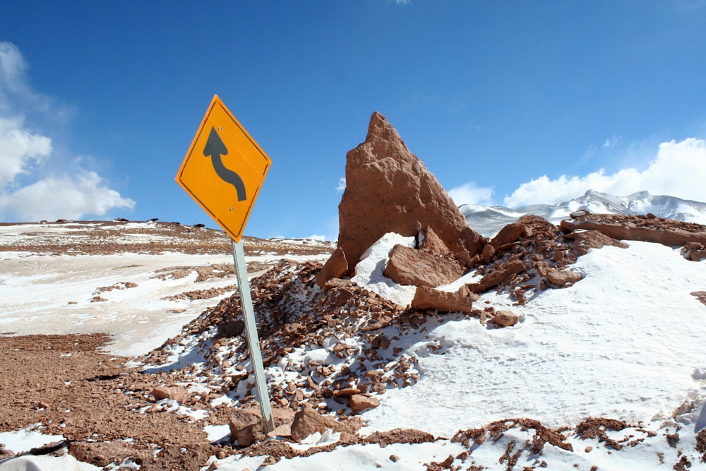 signage near rock formation and snow