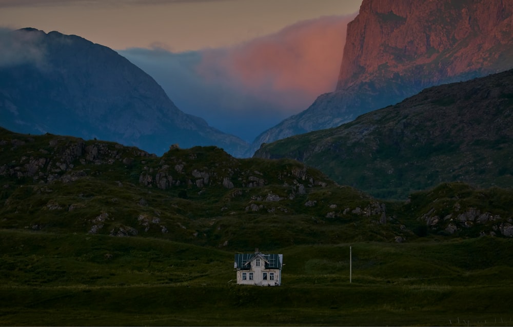 casa de hormigón blanco cerca de la montaña bajo el cielo gris