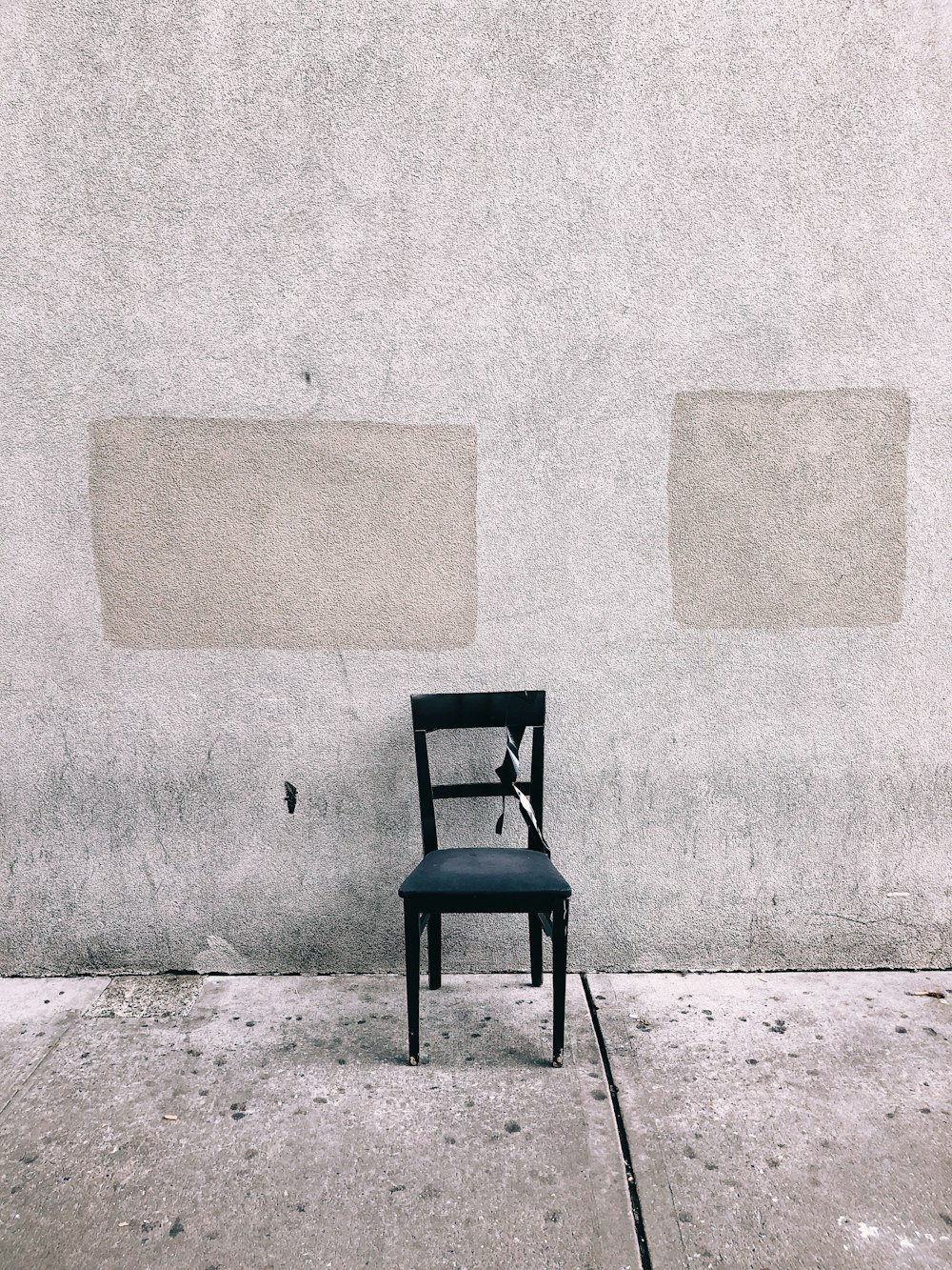 black dining chair beside wall